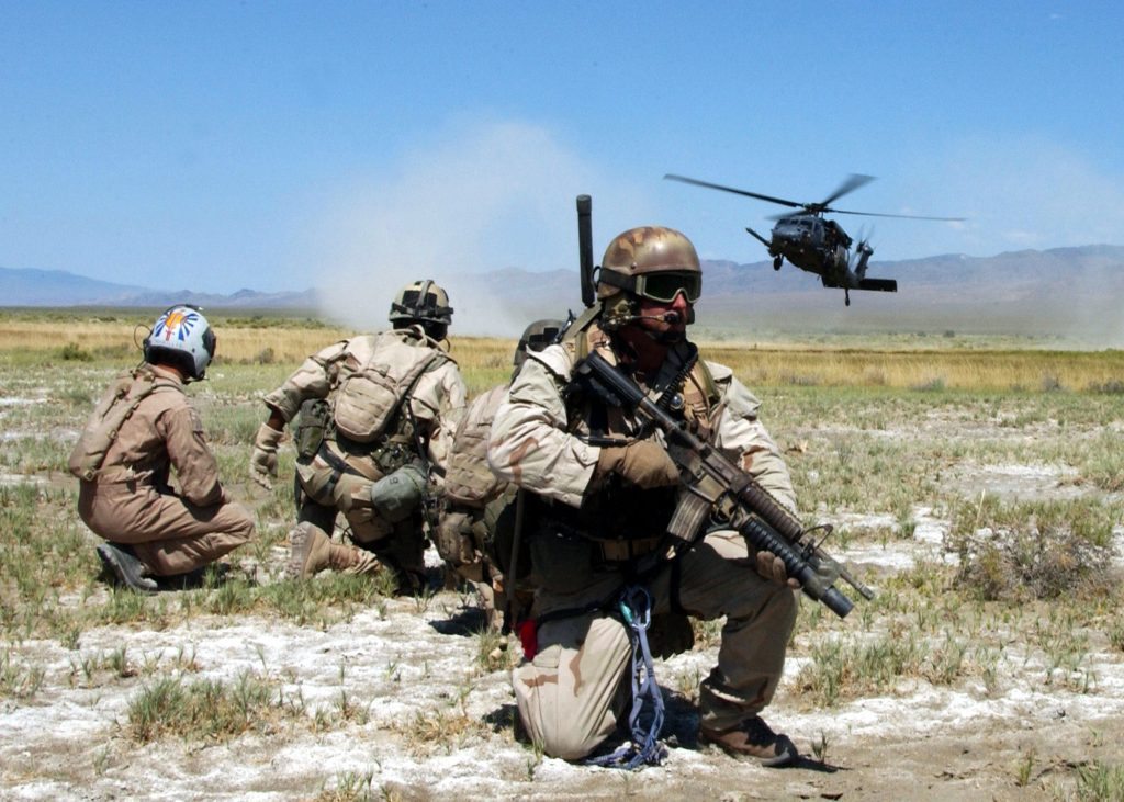 050713-N-9500T-250 Fallon, Nev. (July 13, 2005) -- Pararescuemen and survivors prepare to board an HH-60G Pavehawk helicopter during a training scenario as part of Desert Rescue. Desert Rescue is a multi-service, multi-national training exercise held annually to prepare combat search and rescue teams to extract downed personnel in a variety of environments and situations. U.S. Navy Photo By Photographer's Mate Second Class (AW/NAC) Scott Taylor (RELEASED).