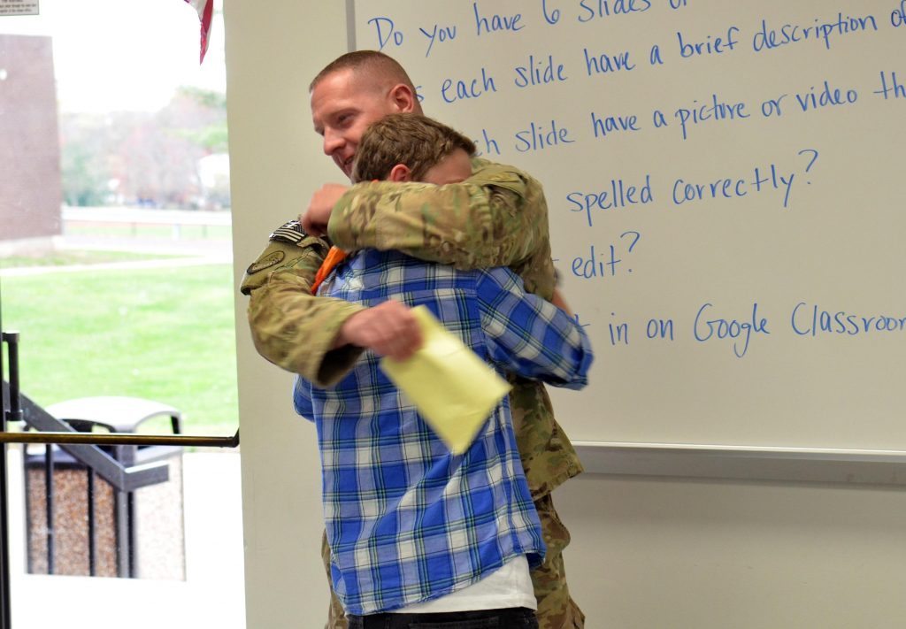 Pennsylvania Air National Guardsman Kevin Curcio pulls his son Bennett into a hug during a surprise visit to his seventh grade Social Studies classroom at Indian Crest Junior High School. Curcio just got back from a deployment to Afghanistan and has not seen his son since March. Wednesday, November 5, 2014. Photo by Geoff Patton
